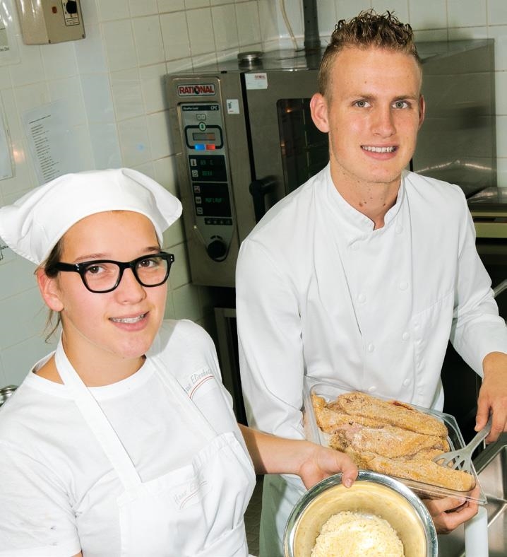 Eine junge Frau und ein junger Mann in Berufskleidung in einer Küche (Caritasverband Trier e. V.)