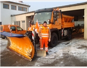 Ein weiterer Mitarbeiter der donauhof-werkstätten hat einen Außenarbeitsplatz in einem Bauhof einer Gemeinde. Das Bild zeigt ihn, ausgerüstet mit einer Schneeschaufel, vor einem LKW mit angebautem Schneepflug.