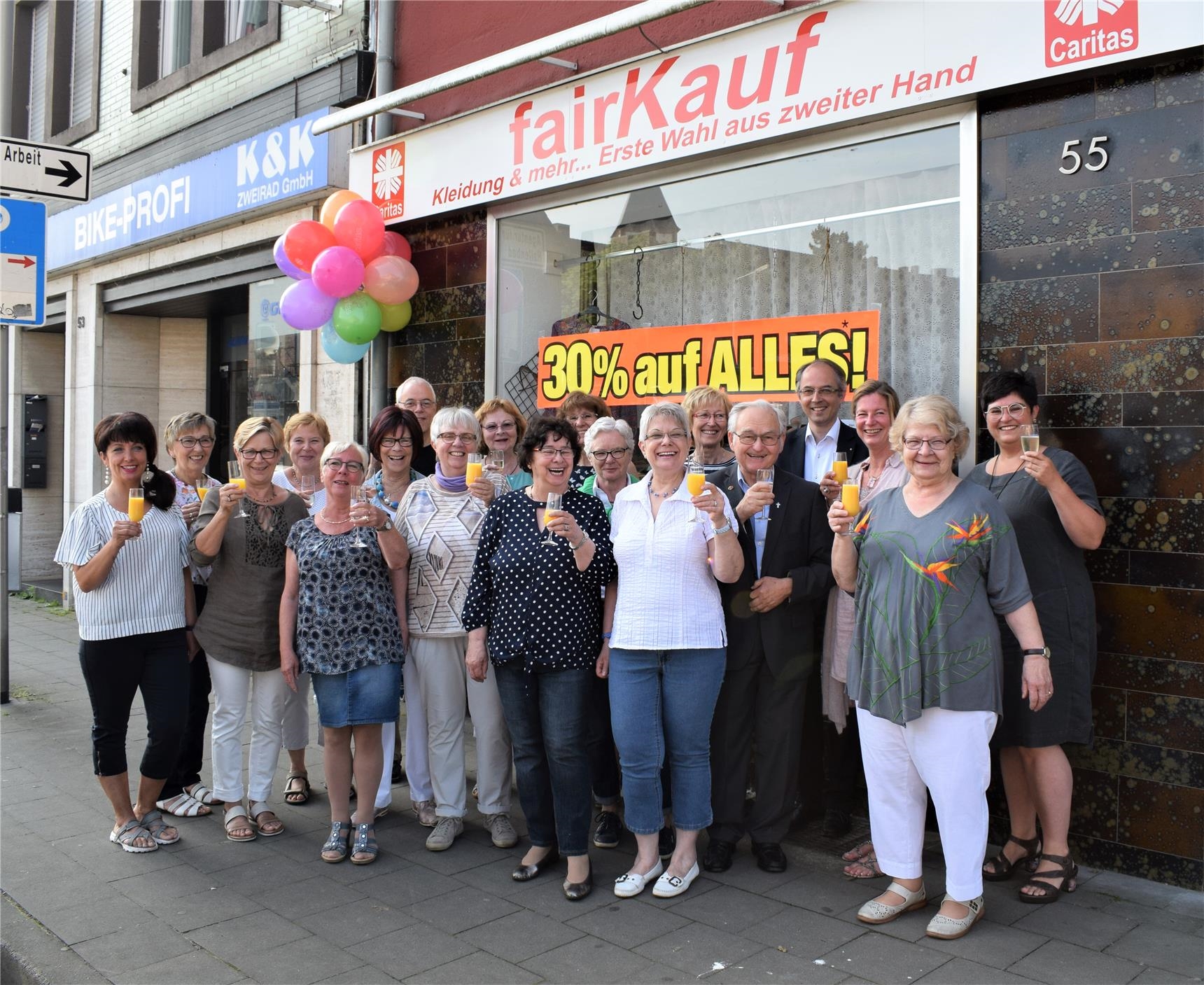 Ein Gläschen in Ehren, um auf die erfolgreichen 10 Jahre anzustoßen: die Ehrenamtlerinnen vor dem Secondhandladen in Jülich (Erik Lehwald)