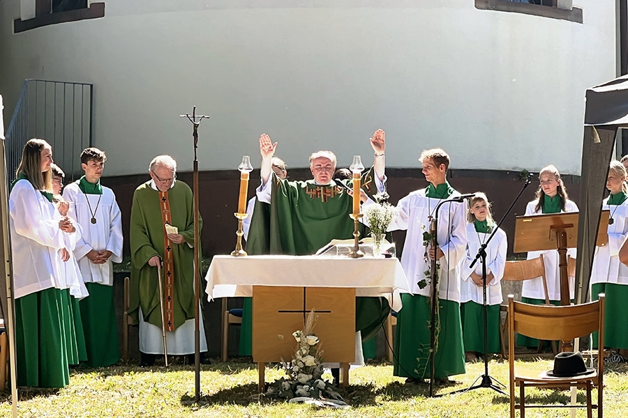 Pfarrer hinter einem Altar, der zur Segnung die Hände hebt (Caritasverband Darmstadt e. V. / Jens Berger)