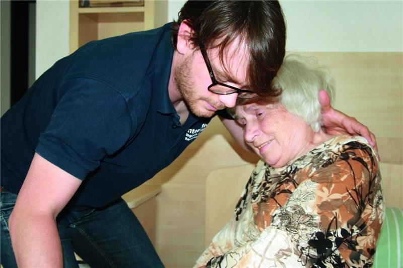 Junger Mann hilft Seniorin