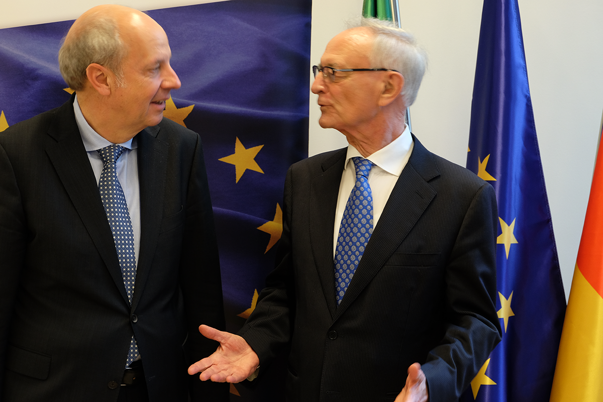Direktor Heinz-Josef Kessmann und Prof. Dr. Klaus Hänsch stehen auf dem CiNW-Europaforum zusammen und reden miteinander. Im Hintergrund sind ein Rollup und drei Flaggen zu sehen. (Markus Lahrmann)