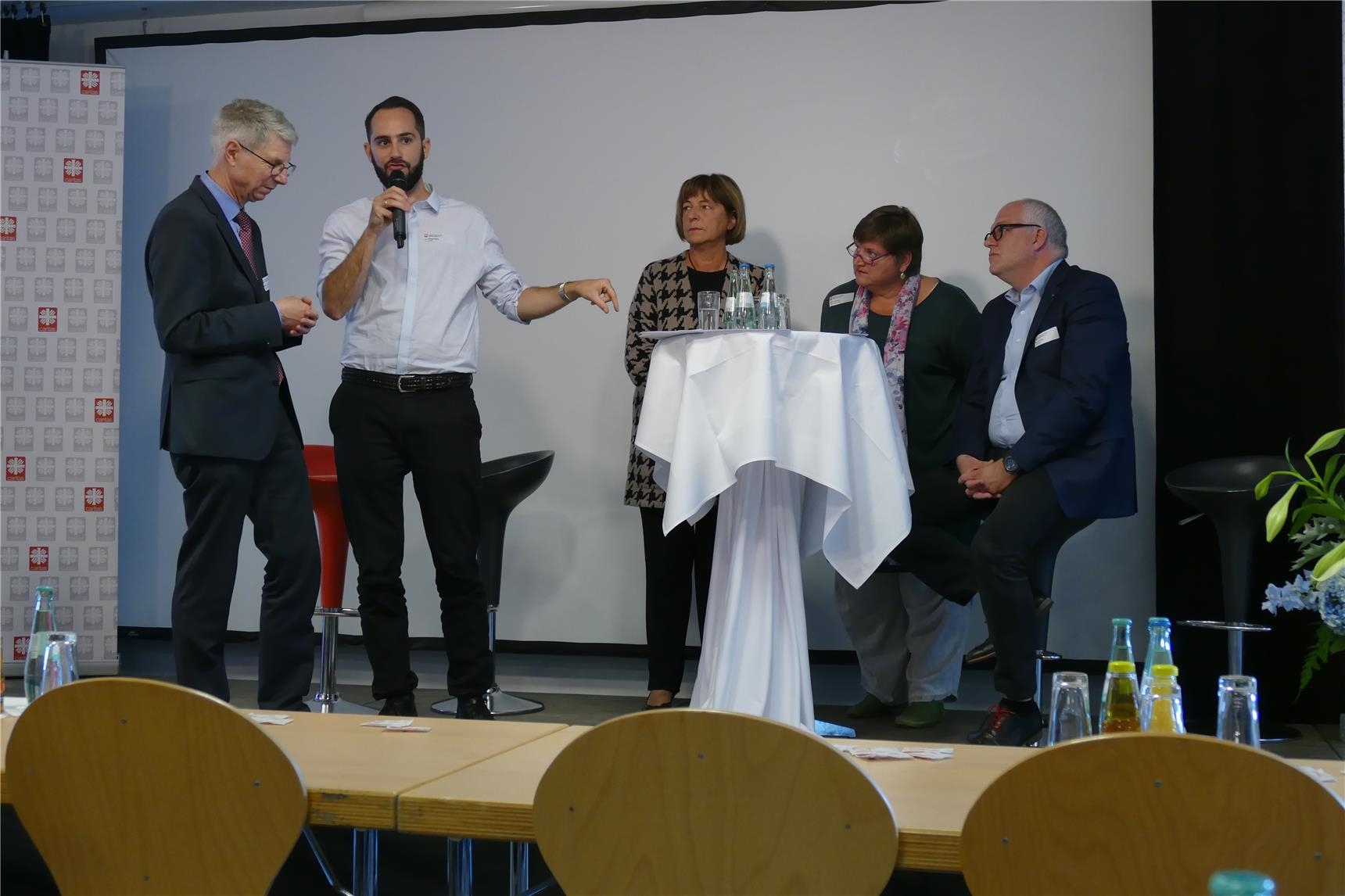 Diskussionsrunde an einem Stehtisch auf Podium (DiCV Aachen)