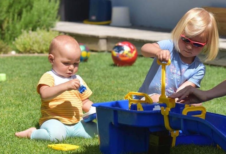 Zwei Kleinkinder spielen mit Bällen und einem Füllspiel.