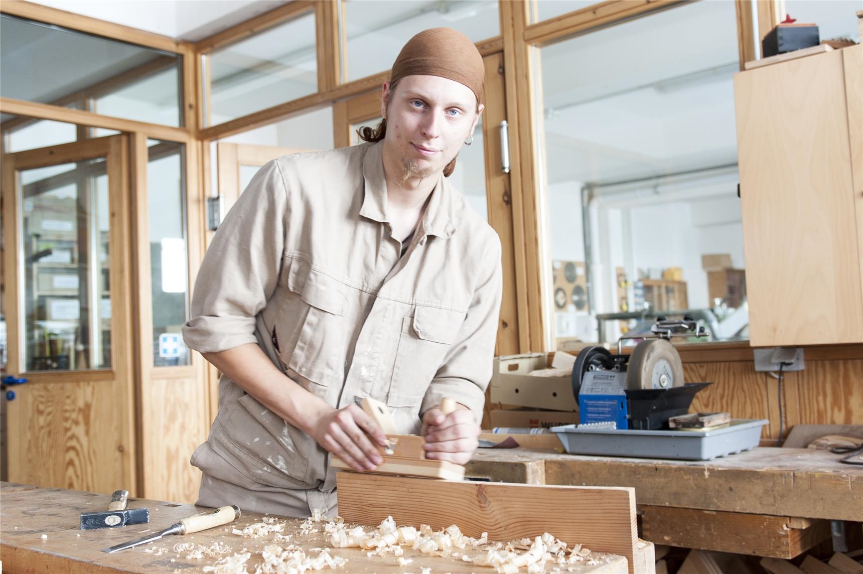 Junger Mann hobelt an der Werkbank in der Jugendwerkstatt Holztechnik der CJS Hannover (Ina Funk)