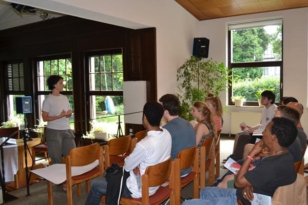 Gruppe von Jugendlichen hört Rednerin zu (youngcaritas Deutschland)