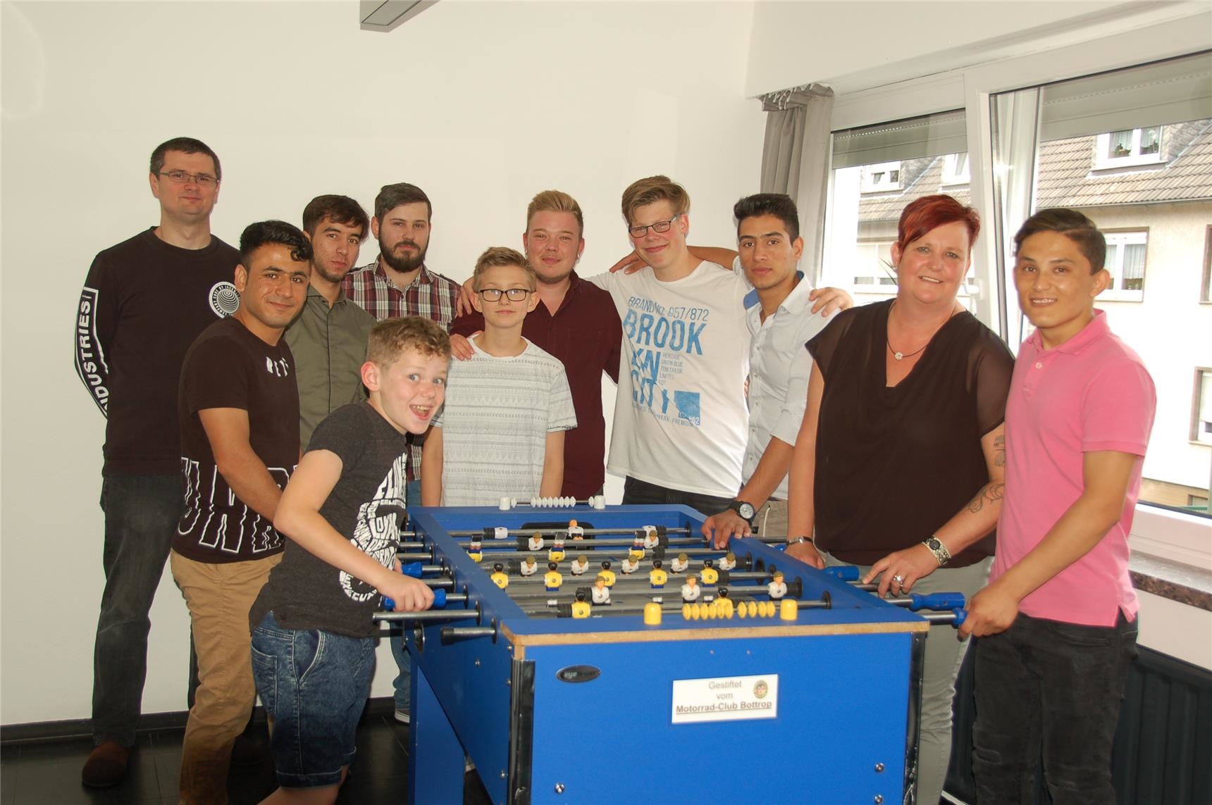 Die Kinder und Jugendlichen der Gruppe Meehrblick mit ihren Erziehern am Kicker (Caritasverband Bottrop - Sigrid Hovestadt)