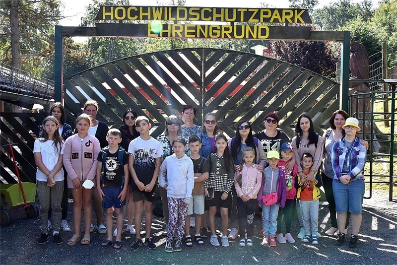 Die Teilnehmer m Besuch des Tierparks haben sich als Gruppe vor dem Tor zusammengestellt.