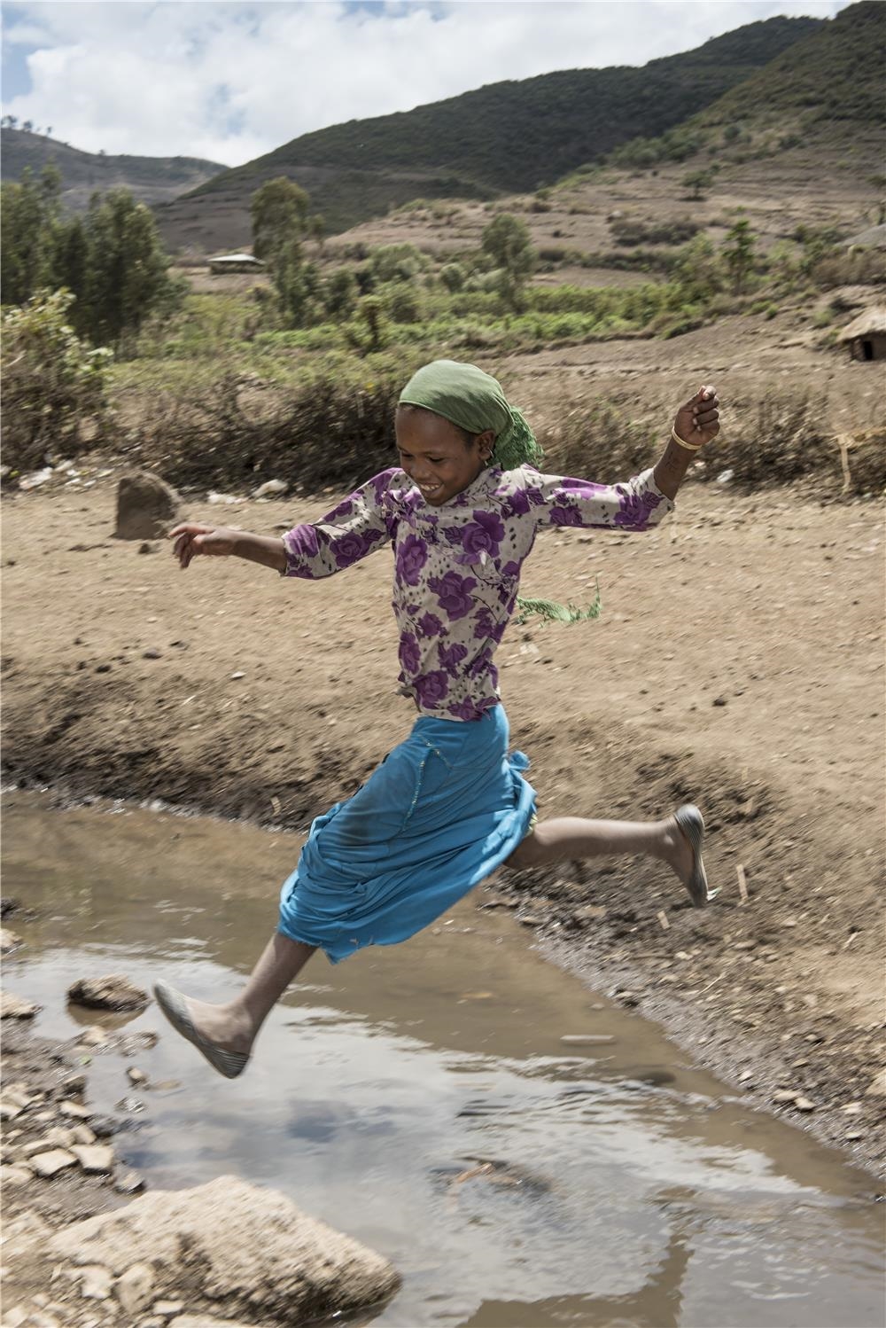 Mädchen springt über einen Fluss (Christoph Gödan)