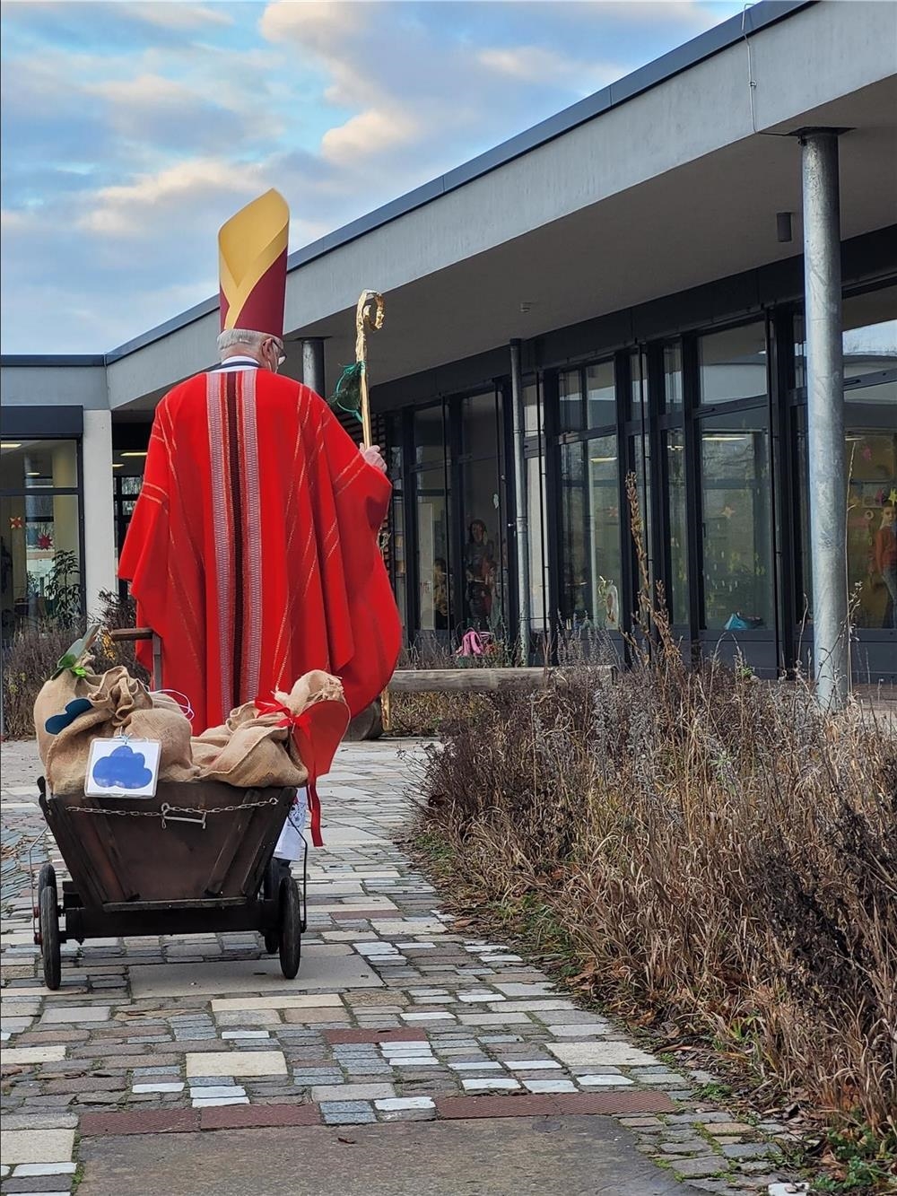 Bischof Nikolaus mit Bollerwagenvor dem Familienzentrum Kita Arche Noah (© Caritasverband Worms e. V.)