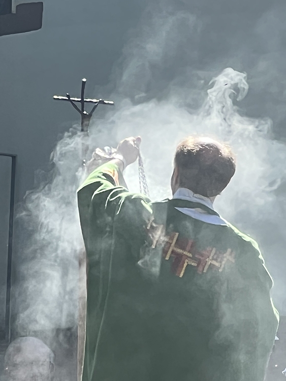 Pfarrer, der vor einem Christuskreuz Weihrauch schwenkt (Caritasverband Darmstadt e. V. / Jens Berger)