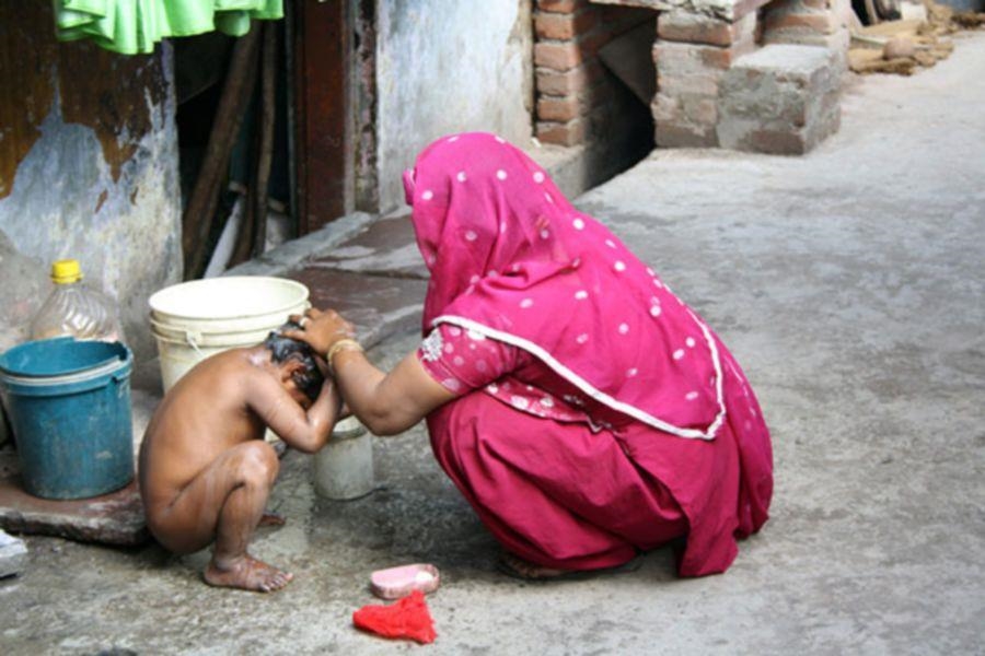 Frau wäscht Kind auf der Straße (Foto: Jörg Schaper)