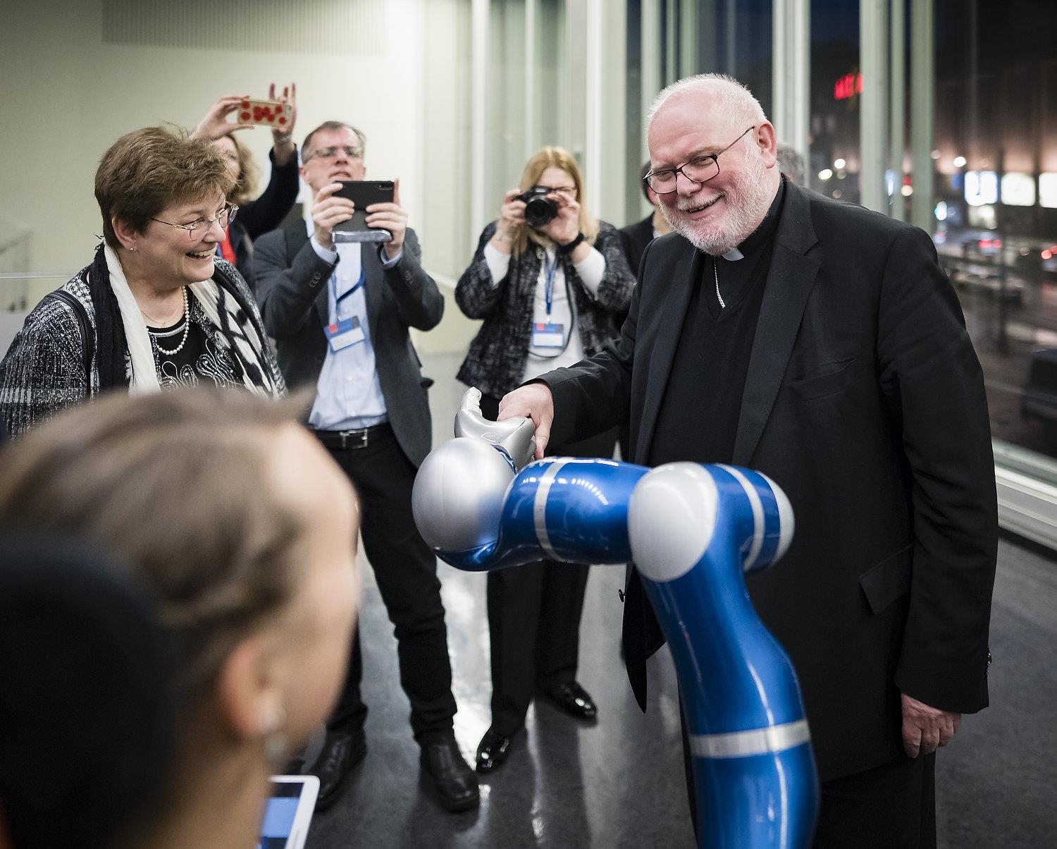 Kardinal Marx schüttelt Roboterarm die Hand (DCV/Xander Heinl)