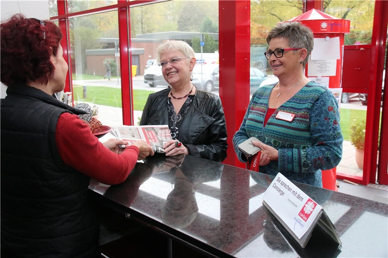 Zwei Damen stehen am Empfang und unterhalten sich mit dem Concierge.