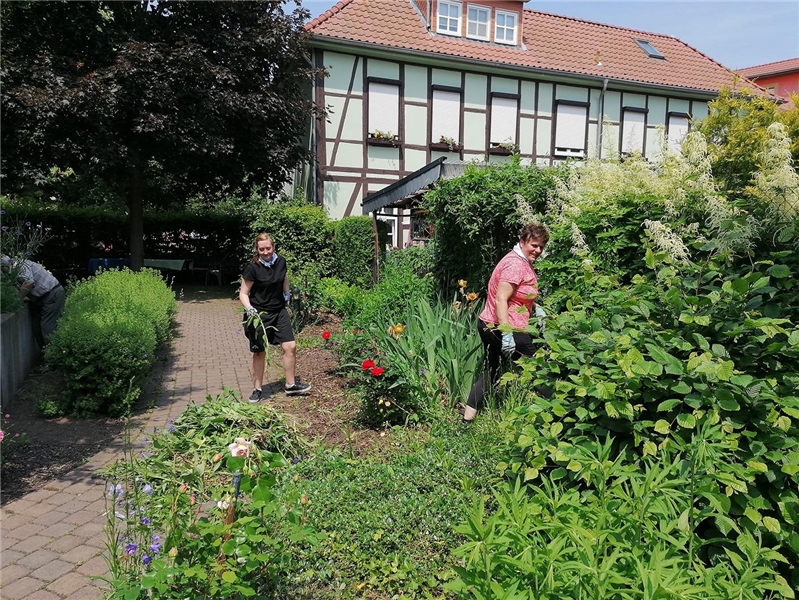 Freiwillige Helfer beim Arbeitseinsatz im Garten