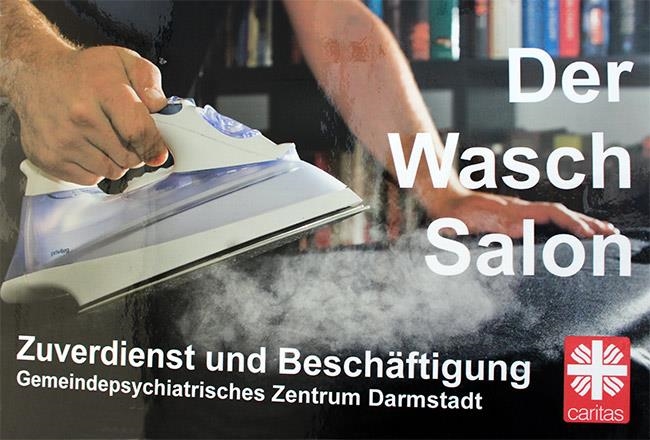 Schild mit der Beschriftung Der Waschsalon – Zuverdienst und Beschäftigung (Caritasverband Darmstadt e. V.)