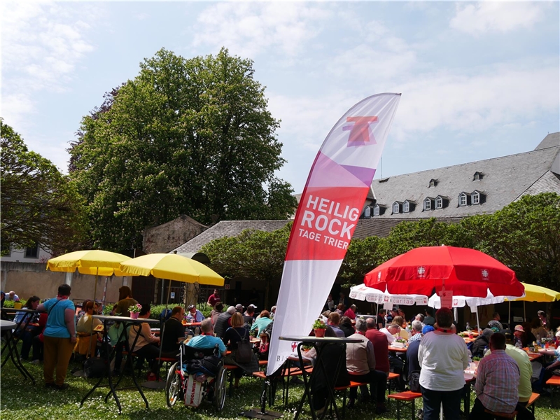 Im Konviktsgarten in Trier sitzen Menschen mit Behinderung zusammen und gestalten ein buntes Programm.
