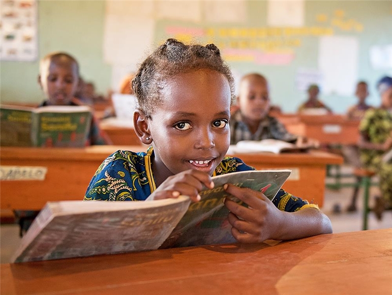 Mädchen mit Lehrbuch in einer Schule  in Nordkenia