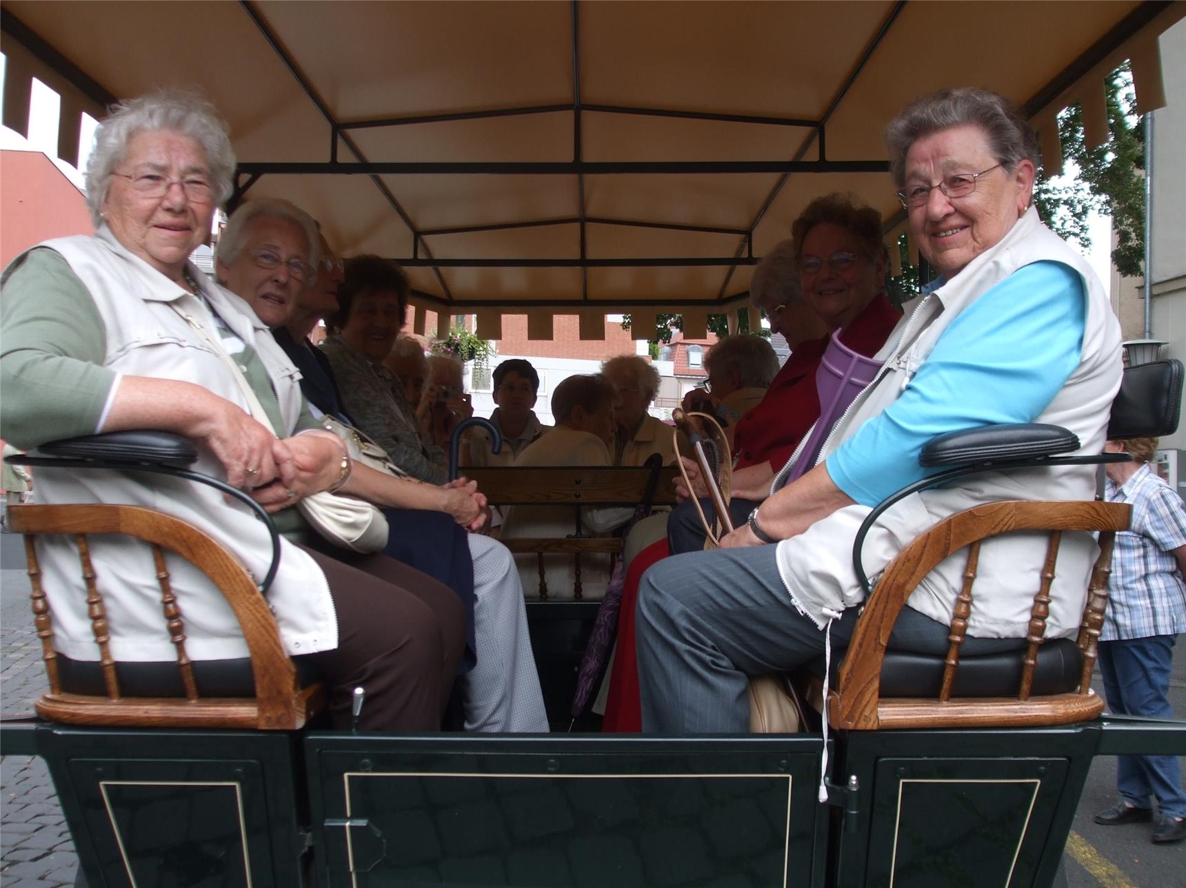 Senioren sitzen in einer überdachten Kutsche (Foto: Caritasverband Koblenz)