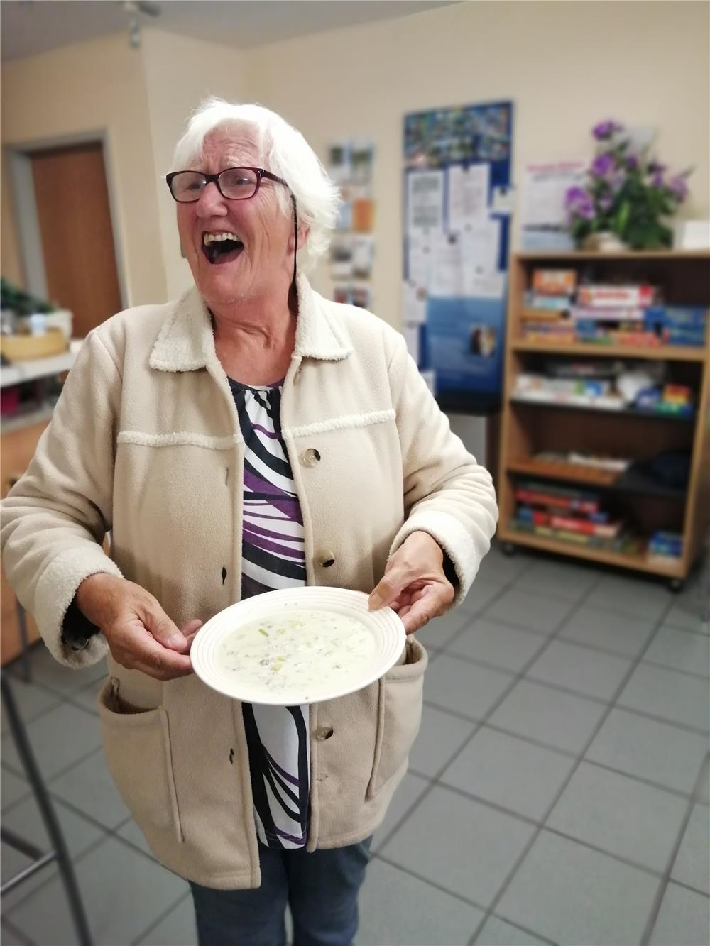 Lachende Frau mit einem Teller in der Hand (Quelle: Caritasverband Gießen)