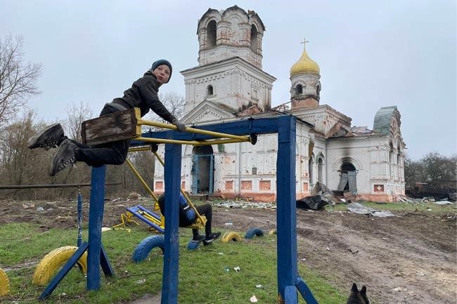 Kind spielt zwischen den Trümmern einer ukrainischen Kirche (Foto: Caritas international)