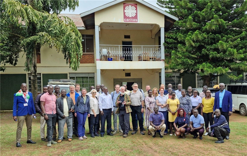 Gruppenbild Caritas Gulu - Personenstehen nebeneinander vor einem Haus