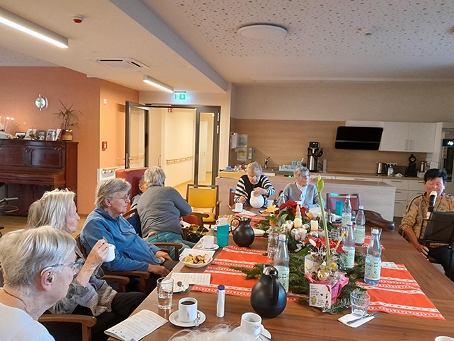 Gemeinsames Cafetrinken an langem Tisch (Caritasverband Darmstadt e. V.)