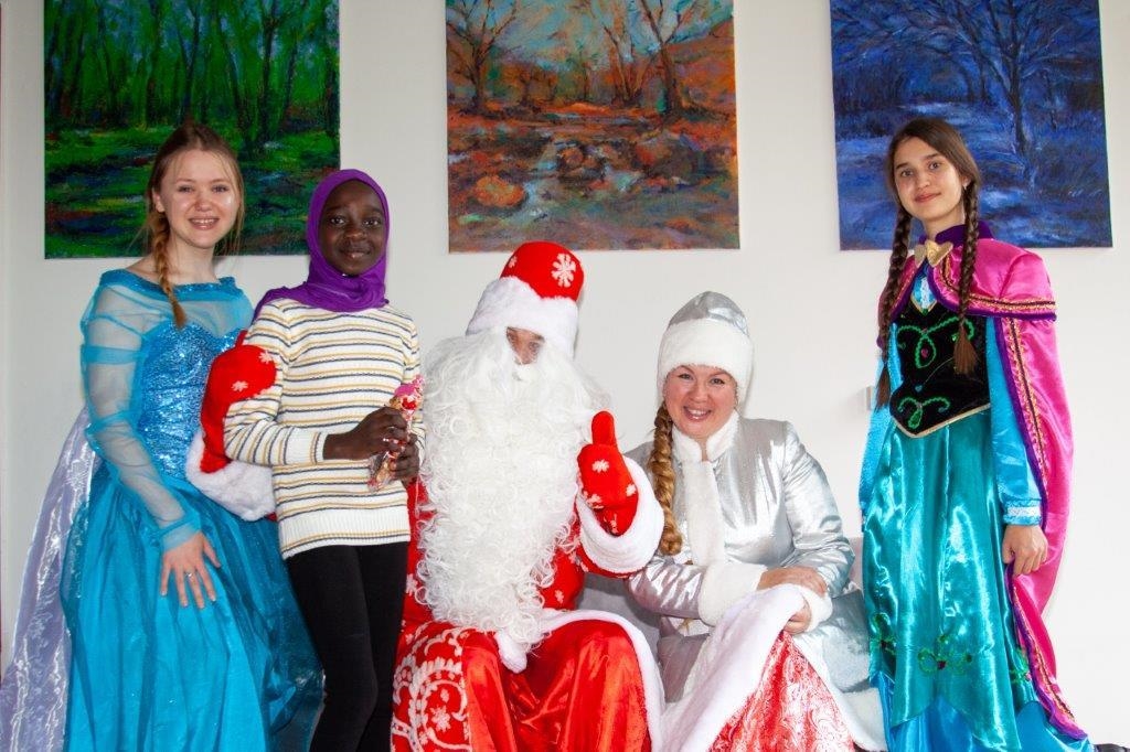 Kinder in tradidionellen Kleidern und der Weihnachtsmann