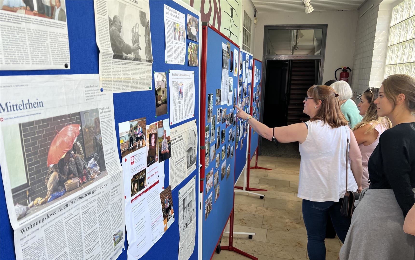 Gäste schauen sich die Stellwände mit den Fotos und Zeitungsberichten aus 25 Jahren Wohnungslosenhilfe an. (Caritasverband Westerwald-Rhein-Lahn e.V. / Holger Pöritzsch)