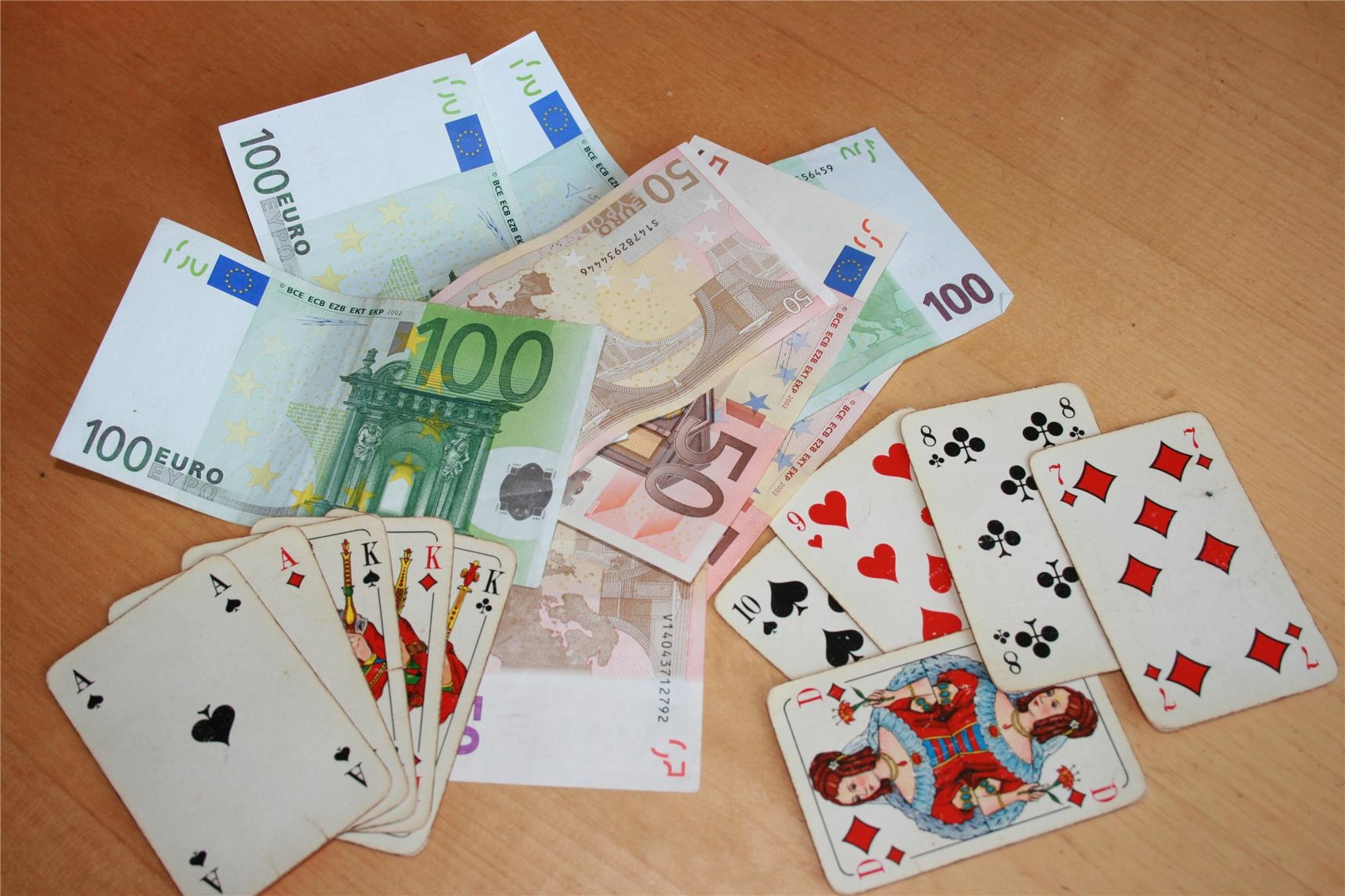 Spielkarten und Geldscheine auf Tischplatte (Foto: Marco Wagner)