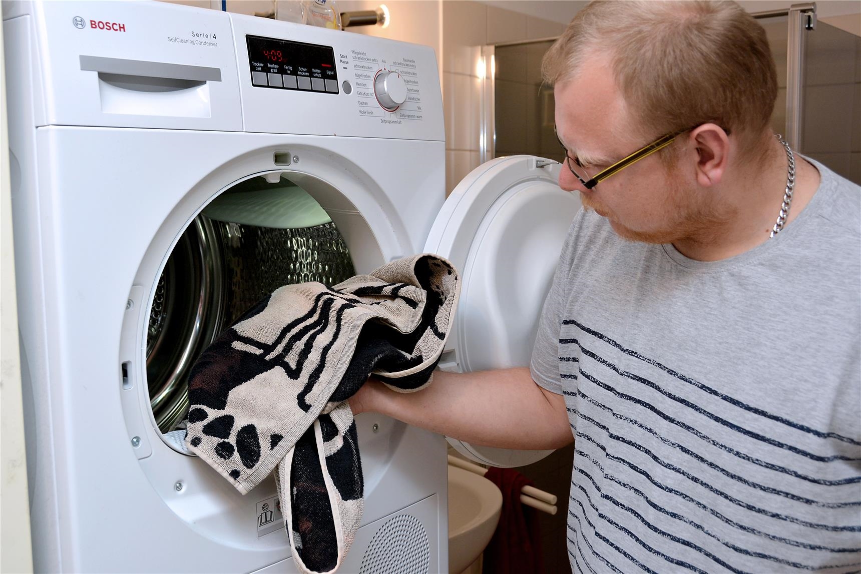Mann bedient Waschmaschine 