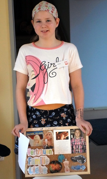 Mädchen hält selbst gestaltetes Poster (Caritasverband für das Dekanat Meißen)