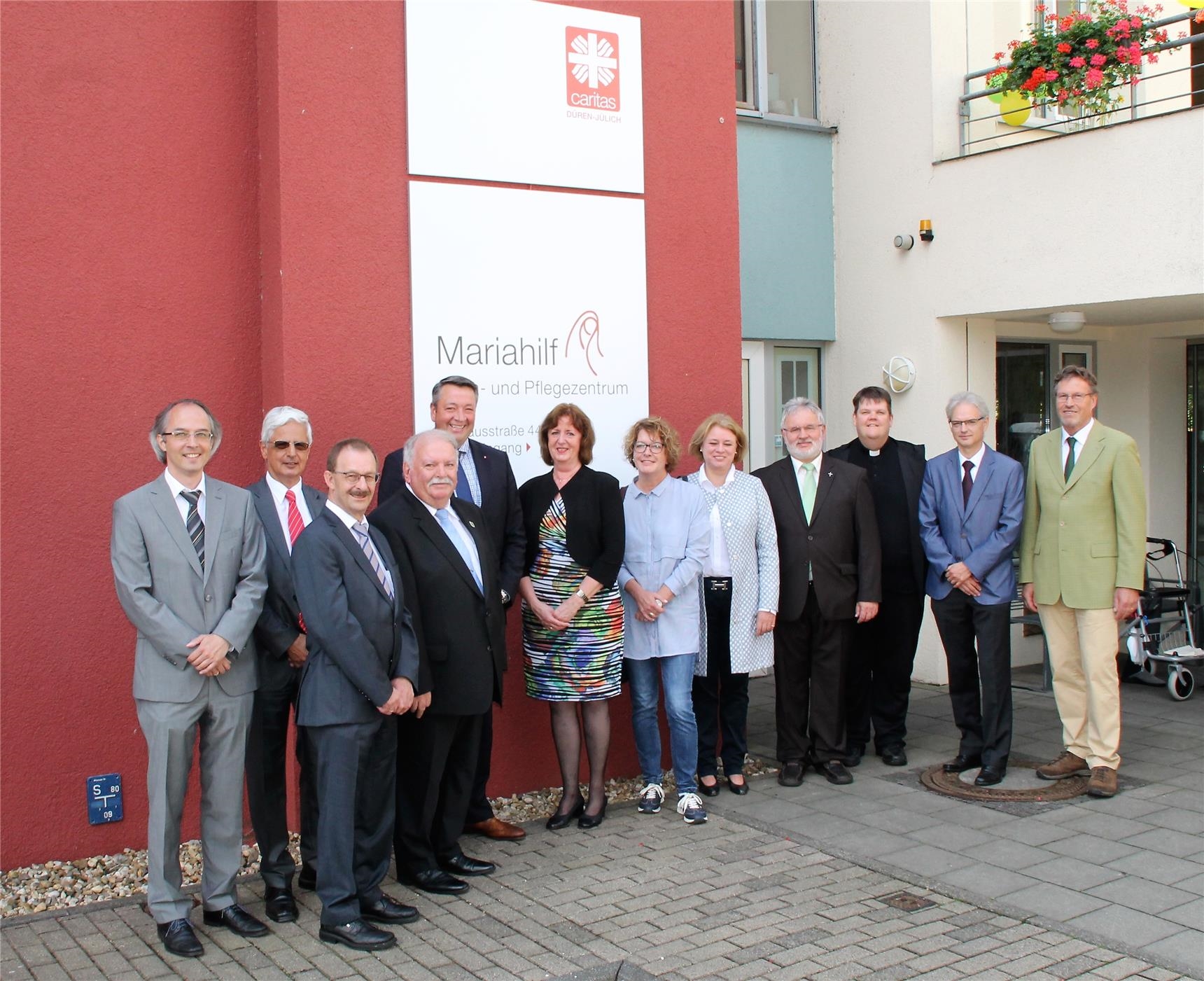 Eine Gruppe aus Caritas-Vorstand und -Mitarbeitern freut sich mit den Festrednern vor dem Altenheim Mariahilf in Nörvenich (Lehwald/Caritasverband)