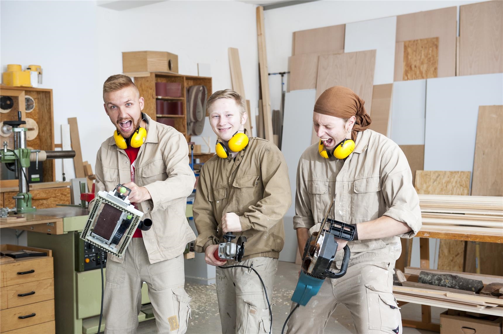 Drei junge Männer in der Jugendwerkstatt Holztechnik der CJS Hannover haben Spaß mit Werkzeugen (Ina Funk)