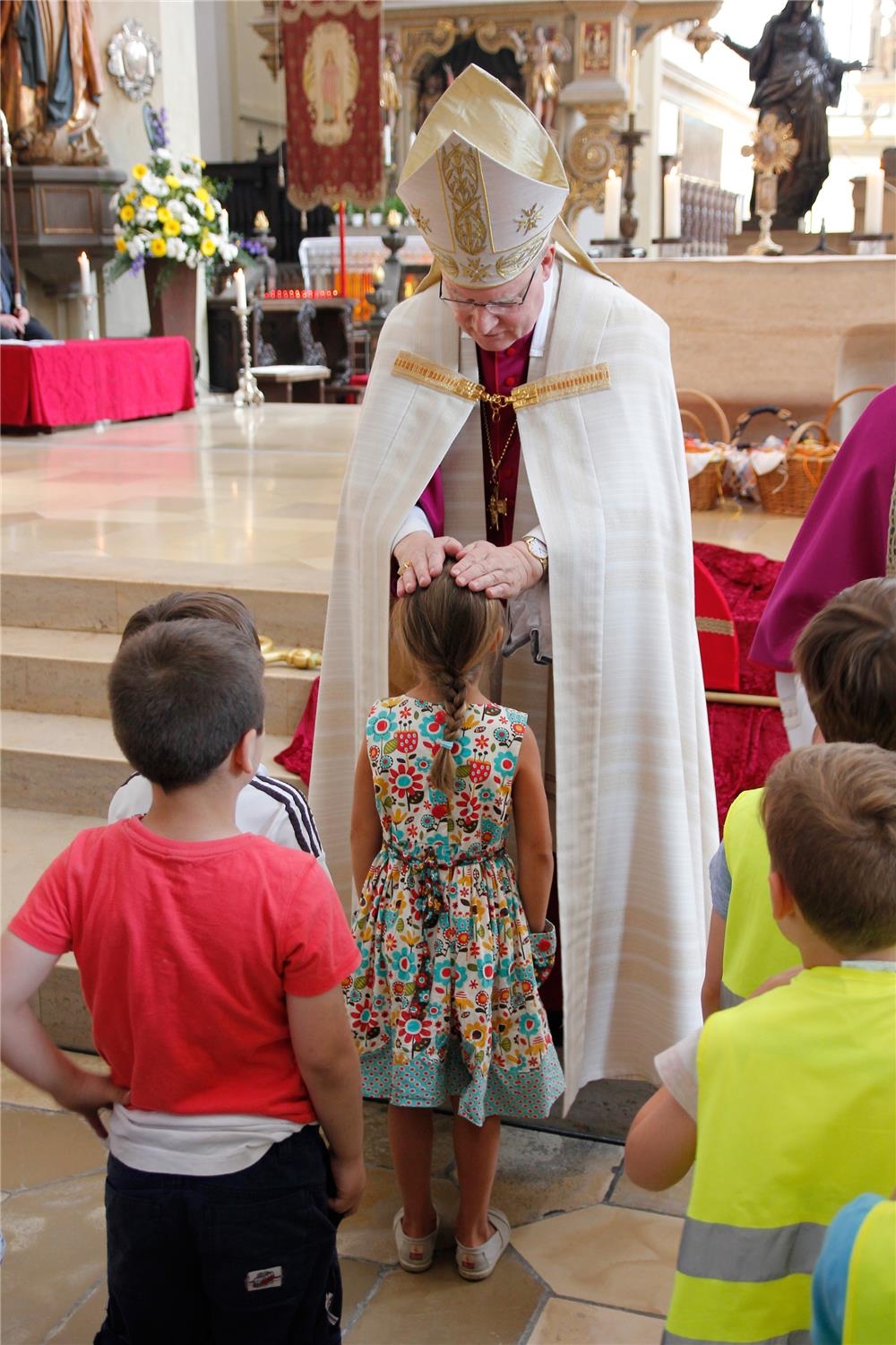 Bischof Dr. Konrad Zdarsa spendet Kindern den Einzelsegen. (Bernhard Gattner)