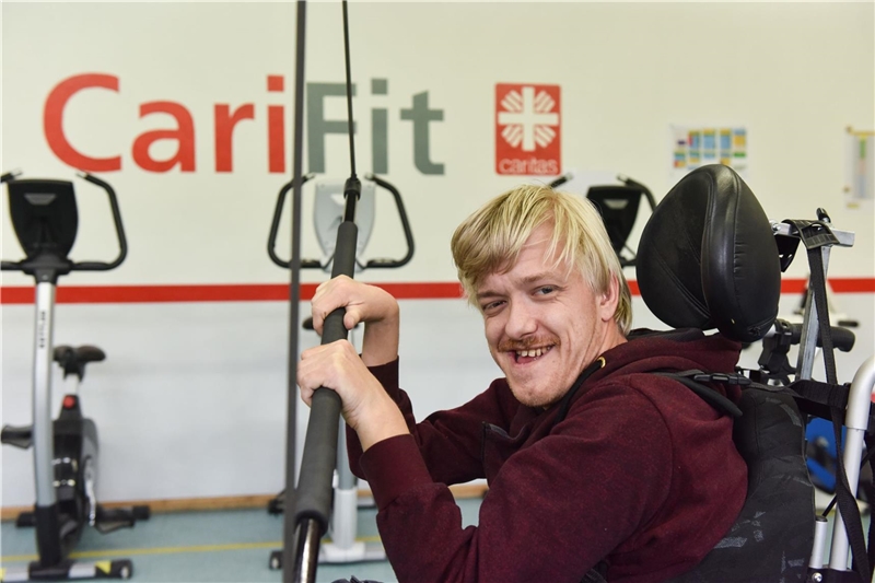 Mann im Rollstuhl trainiert im Gymnastikraum