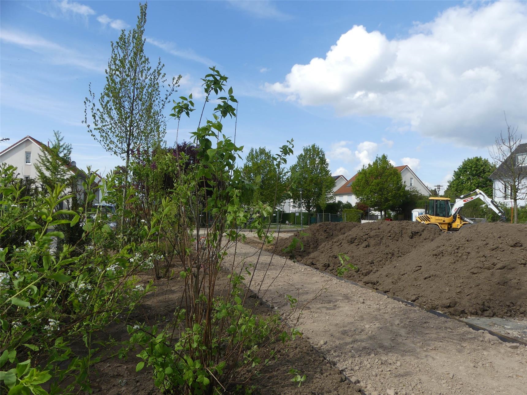 Blick auf die entstehende Gartenanlage von Haus Raphael | Einige Anpflanzungen, ein teilweise angelegter Weg und ein Bagger sind zu sehen (Foto: © Caritas Offenbach / Sabine Schilha)