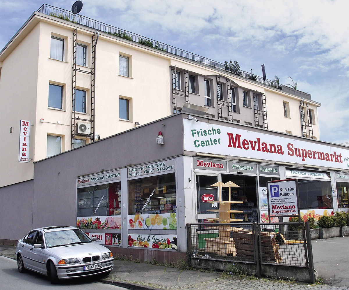 Ein türkischer Supermarkt mit Parkplatz vor dem ein silberner BMW am Straßenrand steht. Im Hintergrund ist der ehemalige Sitz des DiCV Paderborn zu sehen. (Jürgen Sauer)