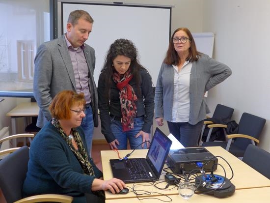 Drei Frauen und ein Mann im Büro, eine Frau sitzt vor einem Laptop (Caritasverband Darmstadt e. V.)