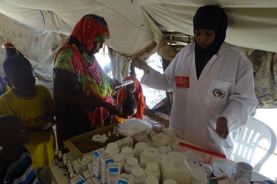 Frau bei der Medikamentenaugabe - Tisch voller Medikamente (Hussien Abdi Isak / WARDI)