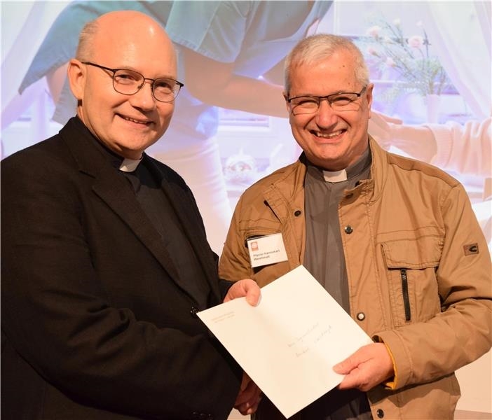 Bischof Dr. Helmut Dieser (l.) überreichte Pfarrer Hannokarl Weishaupt (r.) bei er Vertreterversammlung des Caritasverbandes für das Bistum Aachen in Eschweiler die Ernennungsurkunde zum Bischofsvikar