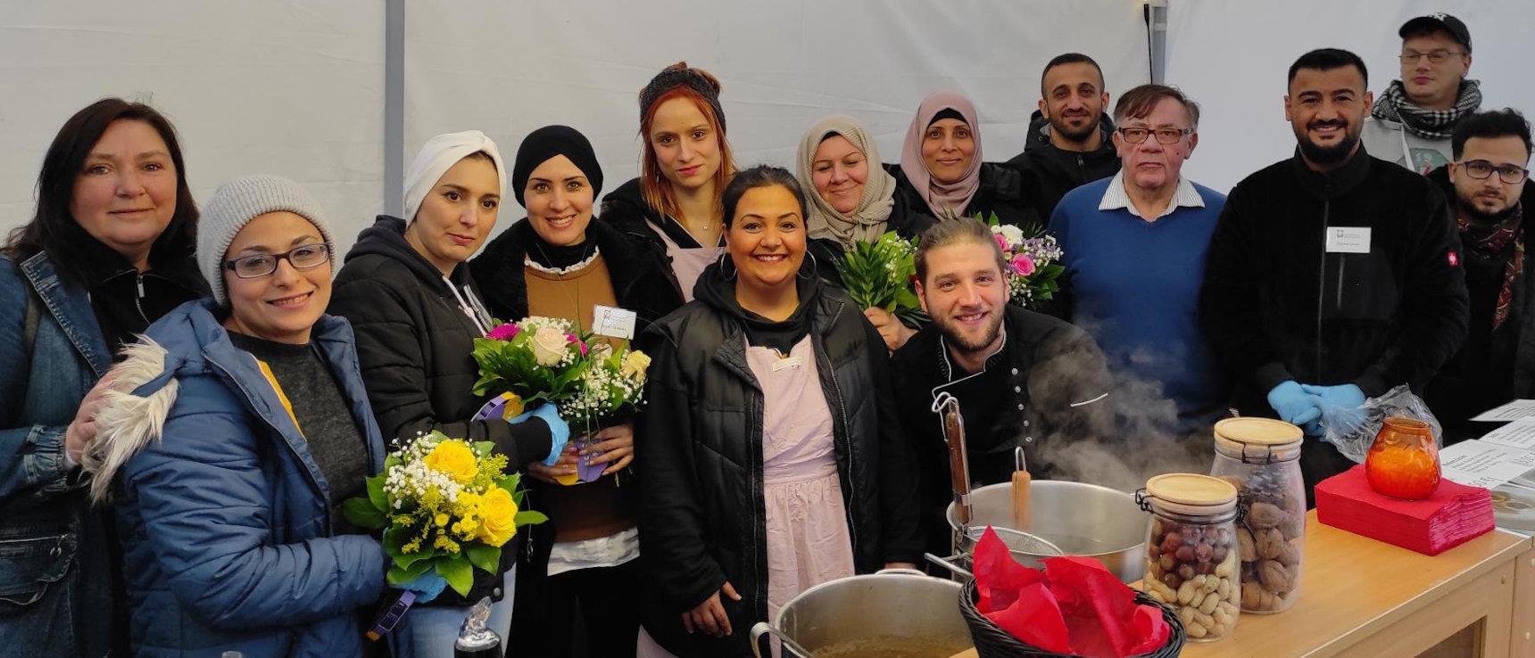 Gruppenbild mit den Helfern des Bistro Jederman und den syrischen Köchinnen bei den Novemberlichtern 2022. 