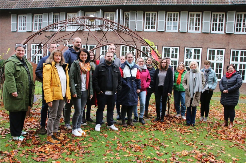 Das Foto zeigt eine Gruppe vor einem Metallgestell im Innenhof eines Gebäudes.