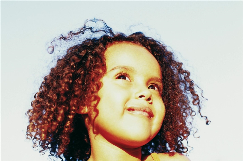 Bild mit lächelndem Mädchen mit schwarzen halblangen Locken