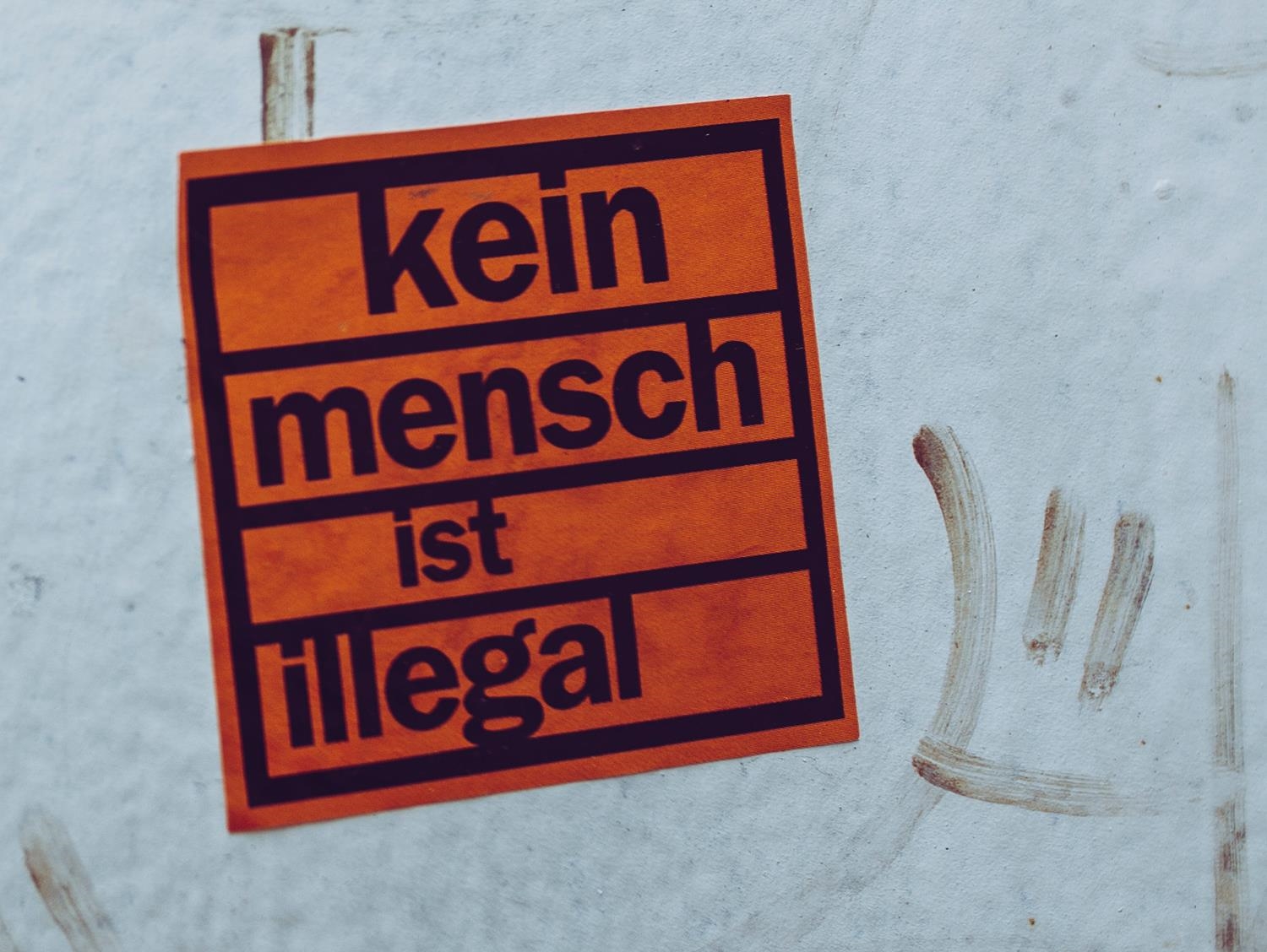 Sticker an Hauswand mit der Aufschrift "Kein Mensch ist illegal"