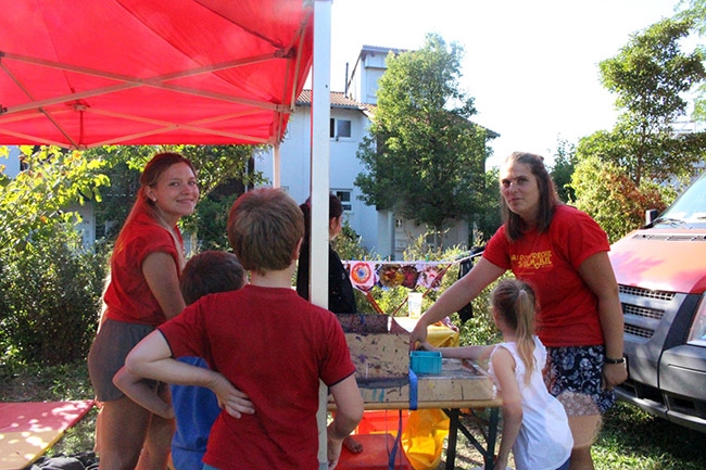 Betreuerinnen mit Kindern an einem Aktionsstand (Caritasverband Darmstadt e. V.)