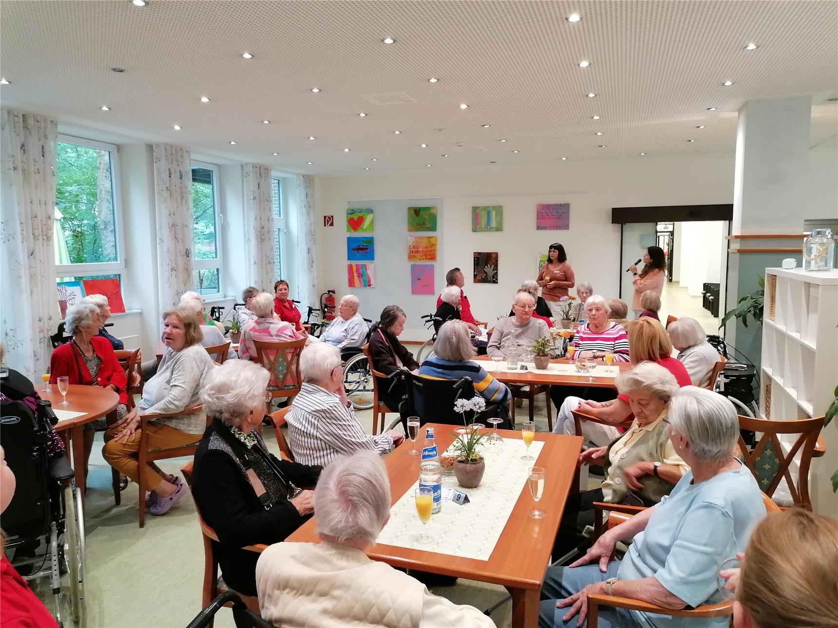 Seniorinnen sitzen zusammen in einem Gemeinschaftsraum 