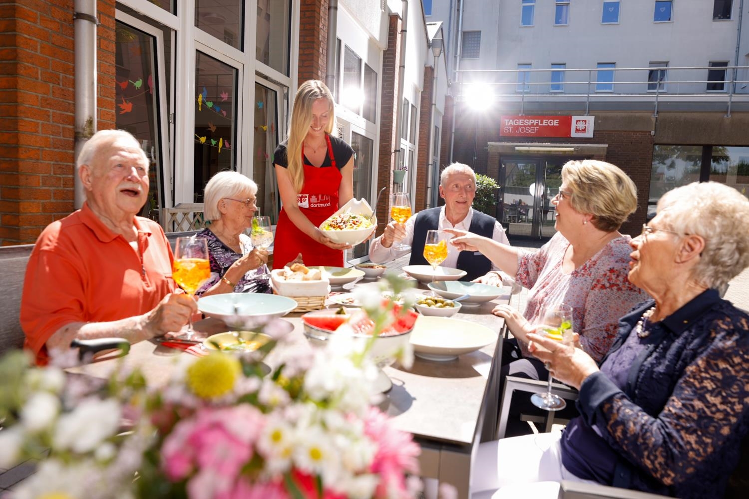 Senior:innen beim gemeinsamen Essen im Freien. 