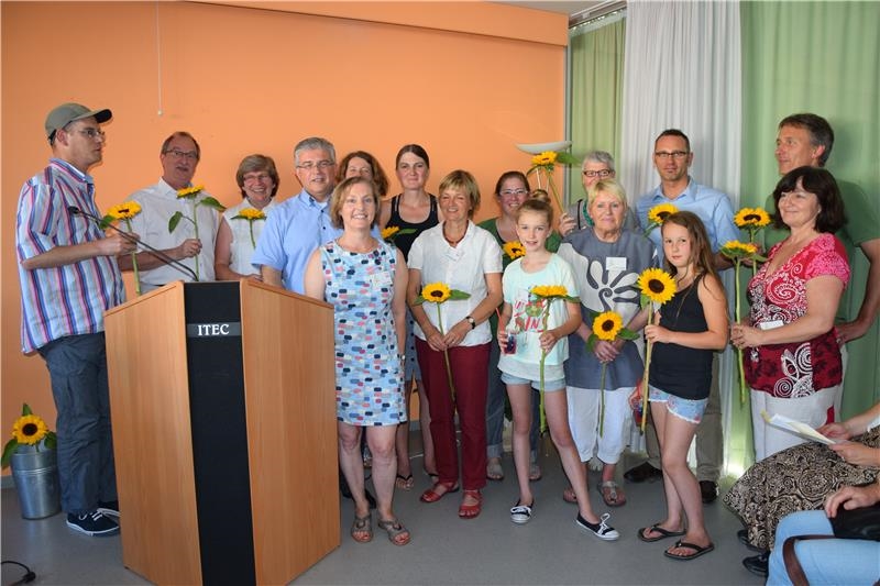 Gruppe bekommt Sonnenblumen überreicht (Caritas Konstanz)