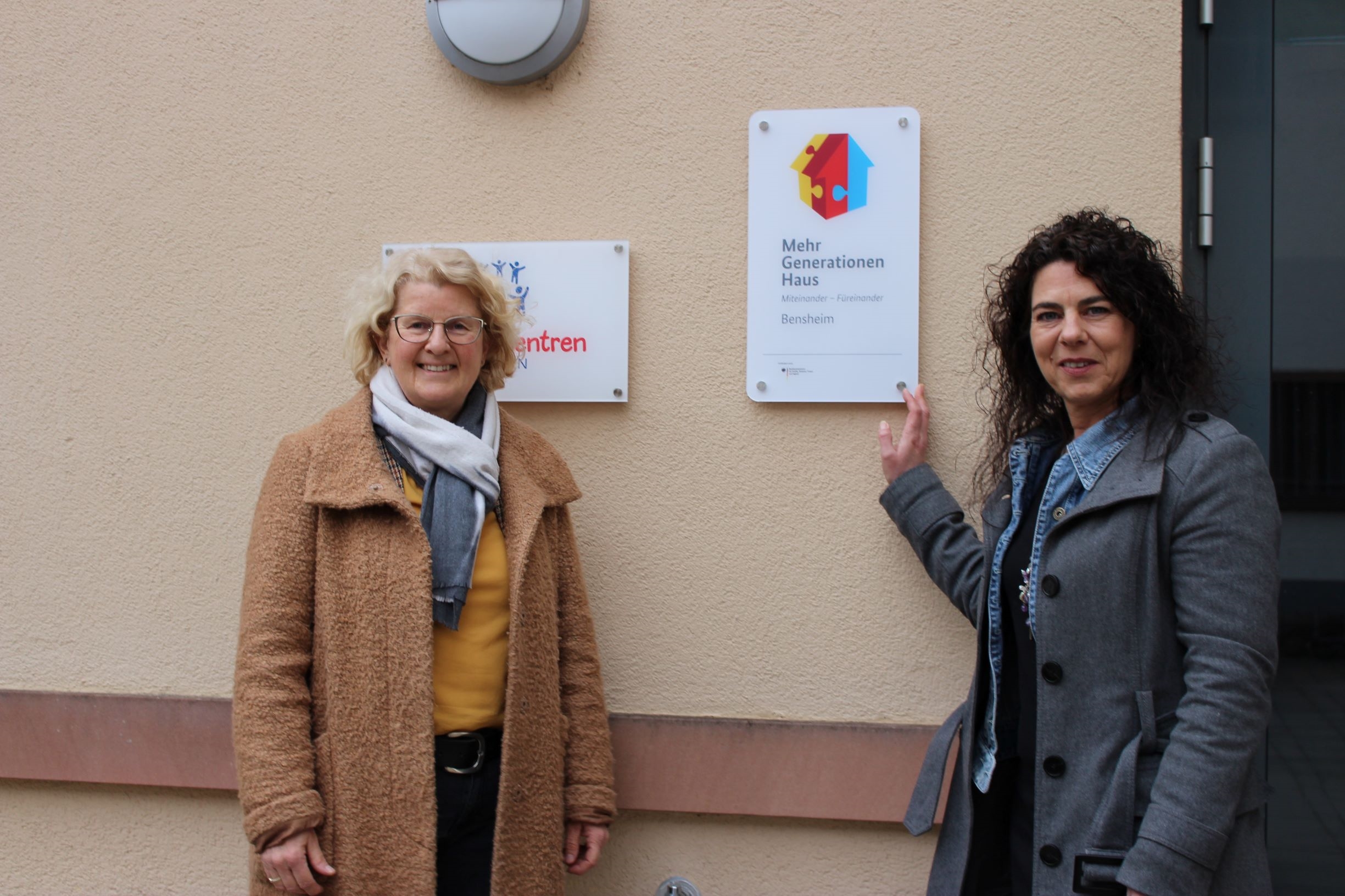 Zwei Frauen vor einem Hausschild (Caritasverband Darmstadt e. V.)